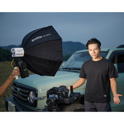 Godox ML60II Bi with AK-B01 adapter being handheld by a lighting assistant