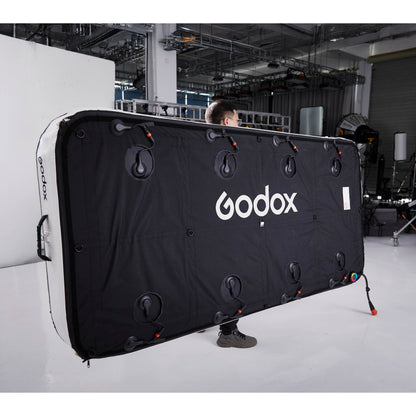 Gaffer carrying a Godox KNOWLED AM1600R-48K 4'x8' Inflatable RGB LED Light Mat showing the back of  the panel