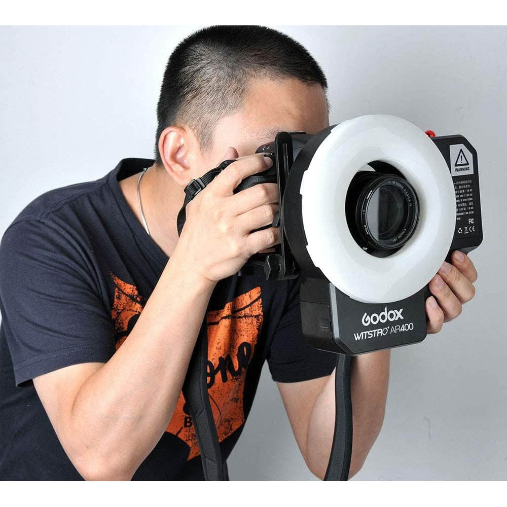 A photographer using a Godox AR400 400Ws Battery-Powered Ring Flash 