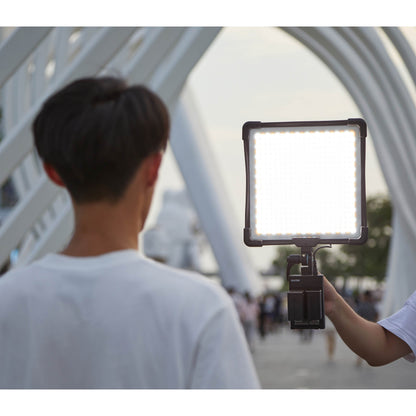 Godox FH50Bi Flexible Bi-Colour LED Light Panel being used outdoors to illuminate their subject's face
