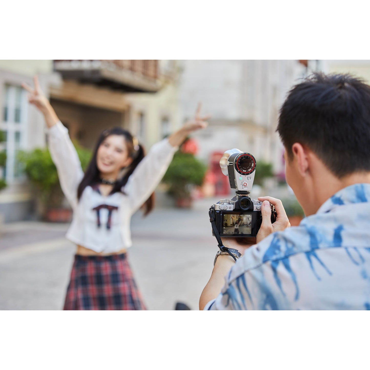 Man taking a photograph of a woman using the Godox Lux Cadet