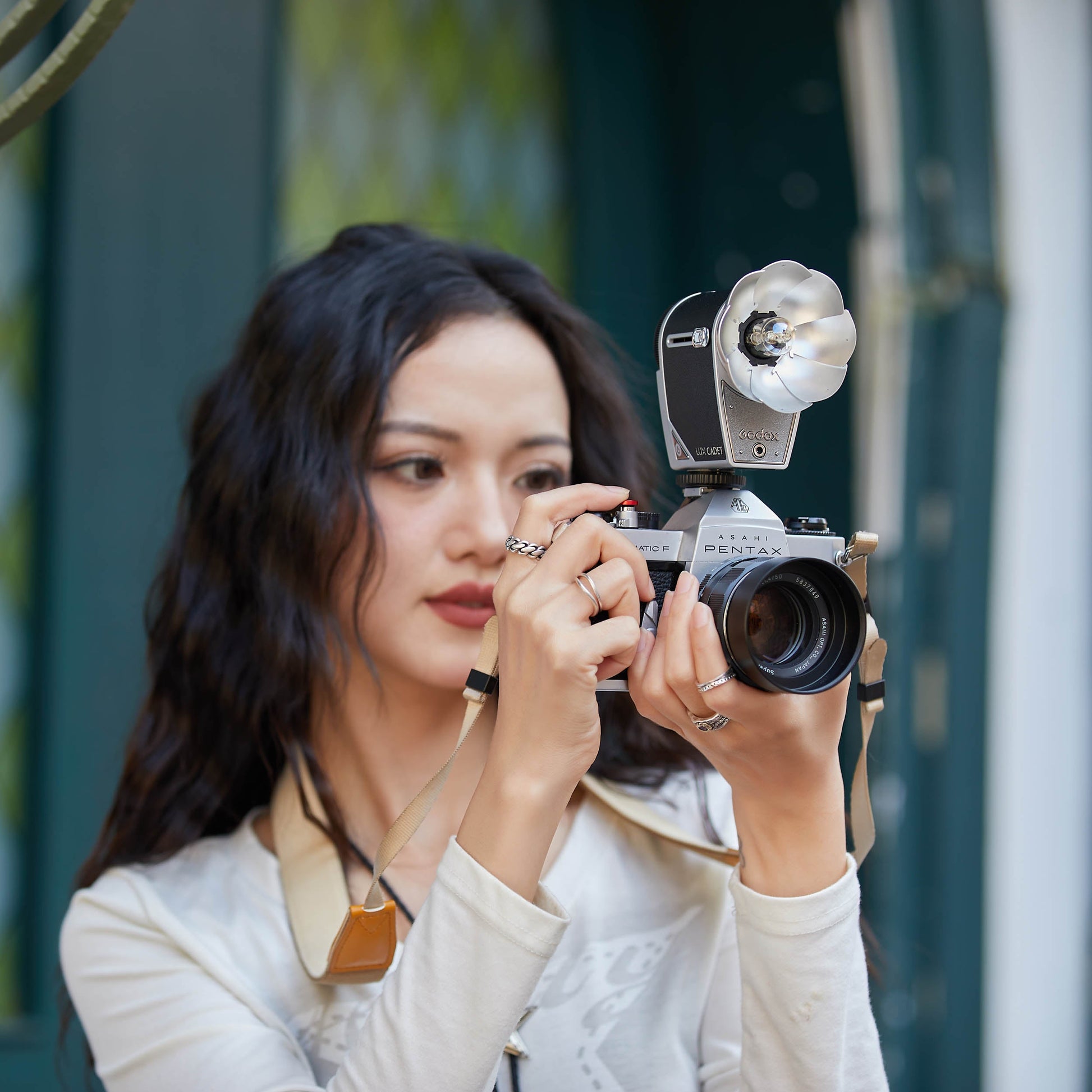 A woman taking a photograph using the Godox Lux Cadet