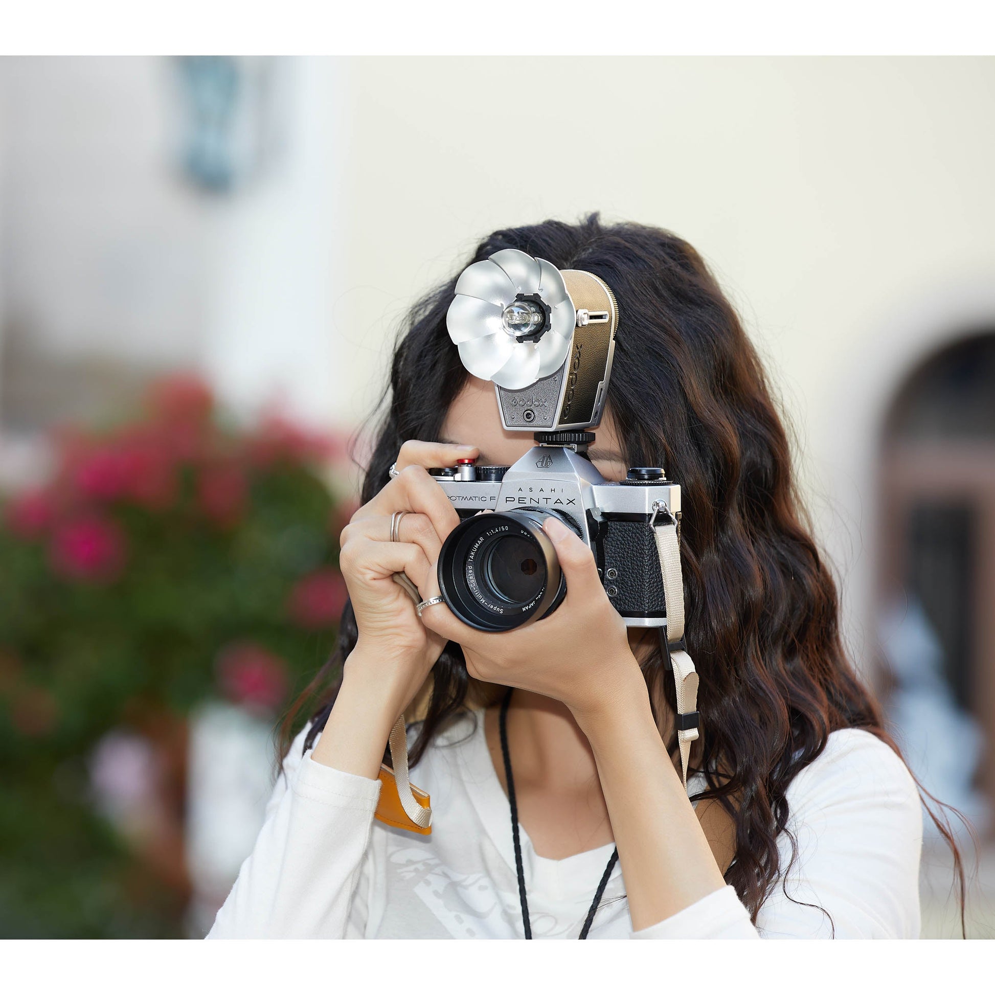 A woman taking a photograph using the Godox Lux Cadet