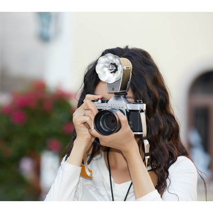 A woman taking a photograph using the Godox Lux Cadet