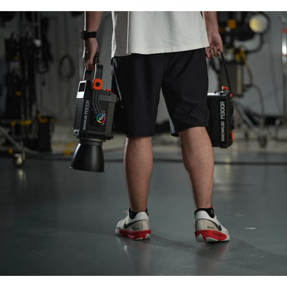 a Gaffer carrying an M300R in one hand and its controller box in the other to show portability