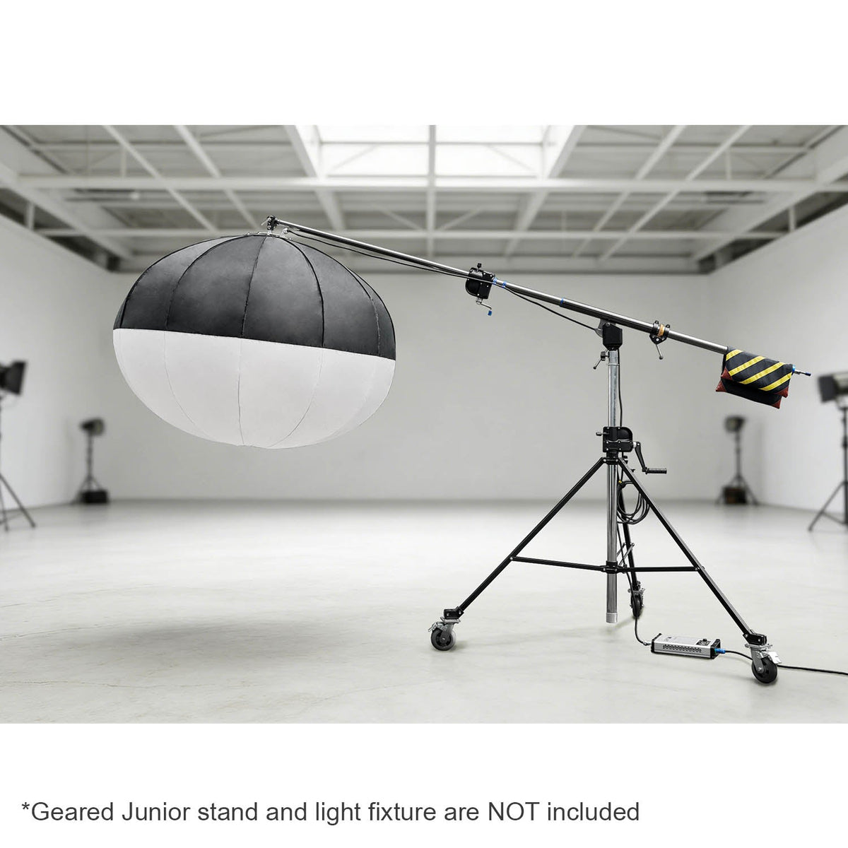 The 222-370cm Heavy-Duty Geared Junior Boom Crane Arm mounted to a junior geared stand with a large lantern mounted to it in a large studio environment