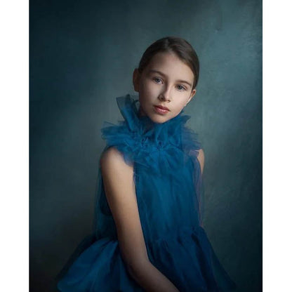 A young girl wearing a blue dress with ruffled details against a 1.5x2.1m Texture Colour Spray Hand-Painted Canvas Photography Backdrop from Kate Backdrops