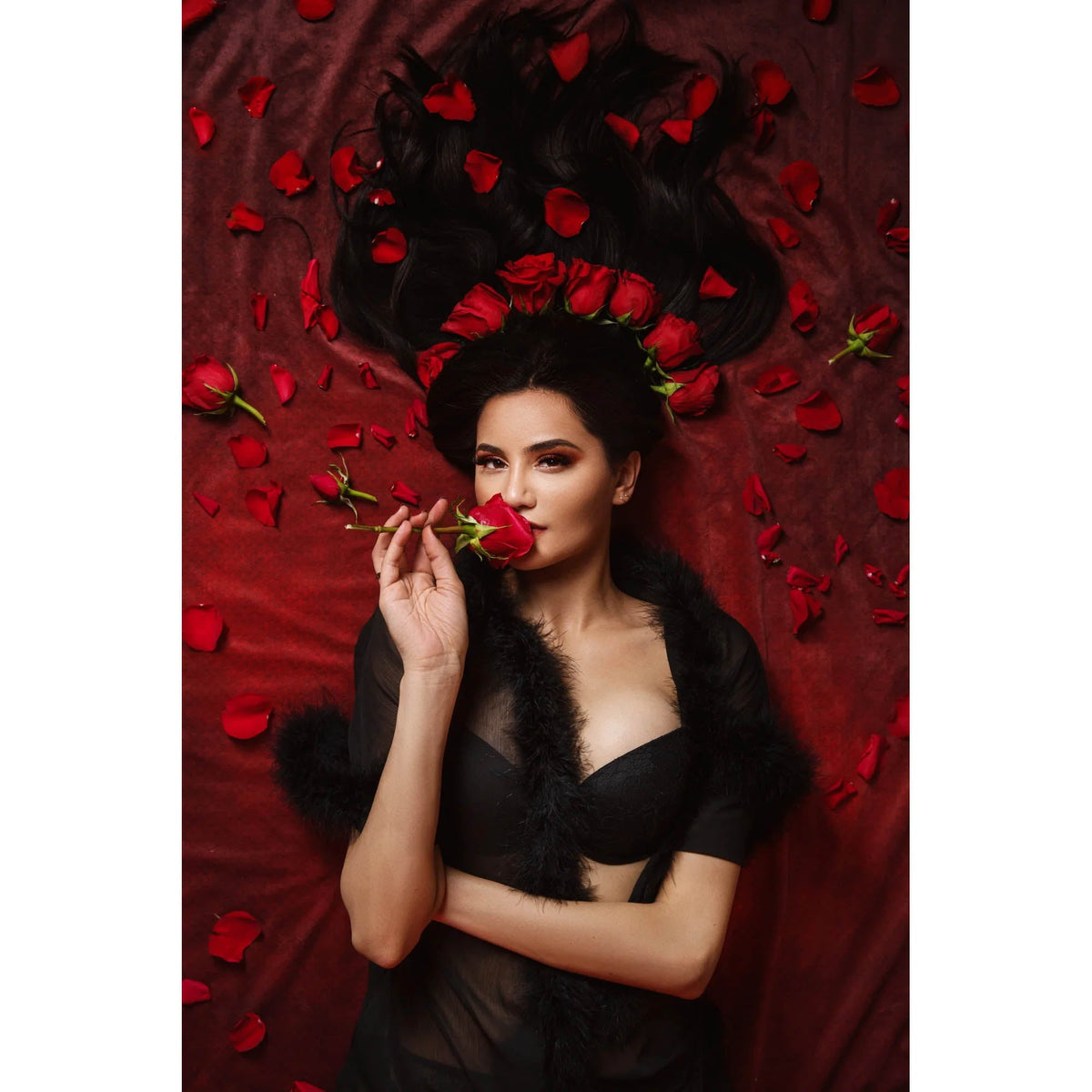 Woman holding a red rose amidst red petals and black feathers on a 2x3 Dark Red Wine Colour Abstract Weave Pattern Texture Studio Photography Background from Kate Backdrops