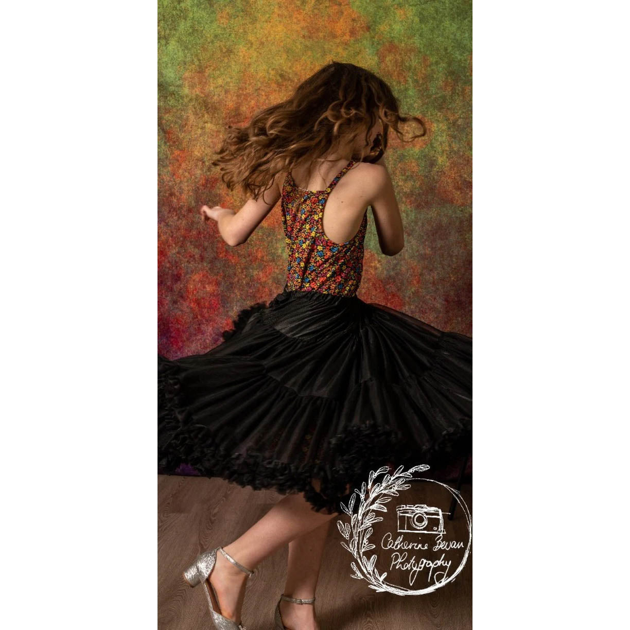 A photograph of a Rhythmic Gymnast in front of a Kate Backdrops 2x3 Abstract Rust Orange Green Textured Studio Backdrop