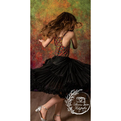 A photograph of a Rhythmic Gymnast in front of a Kate Backdrops 2x3 Abstract Rust Orange Green Textured Studio Backdrop