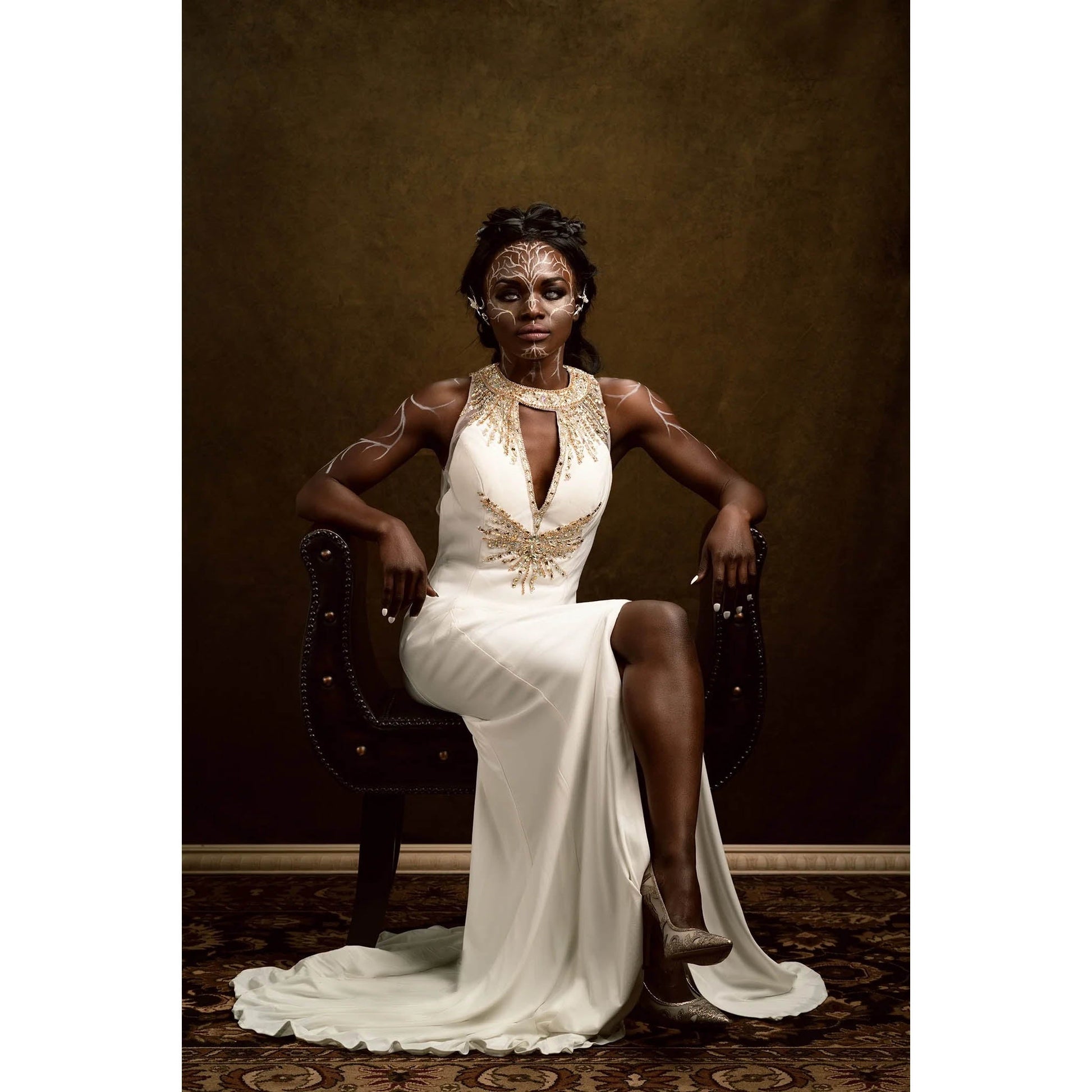 A lady in a dress wearing FX makeup sitting in front of a 3x2m Dark Gold Abstract Horizontal Backdrop 