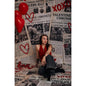 A young woman sitting in front of a Valentine's Day Newspaper Love Hearts Backdrop 
