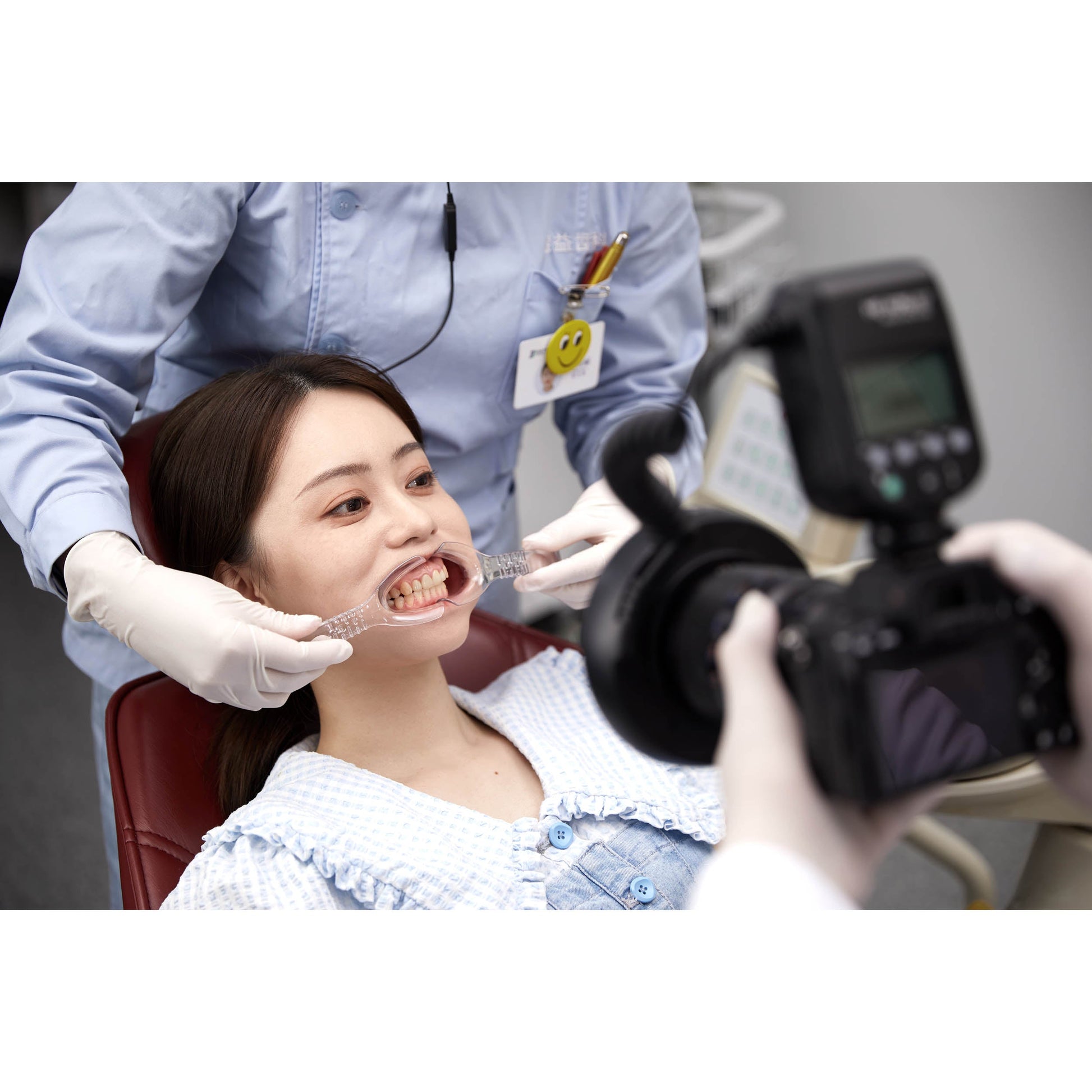 Dentist using the Godox MF-R76S+ Dental Photography Ring Flash on a Patient whilst lips are being retracted by an assistant
